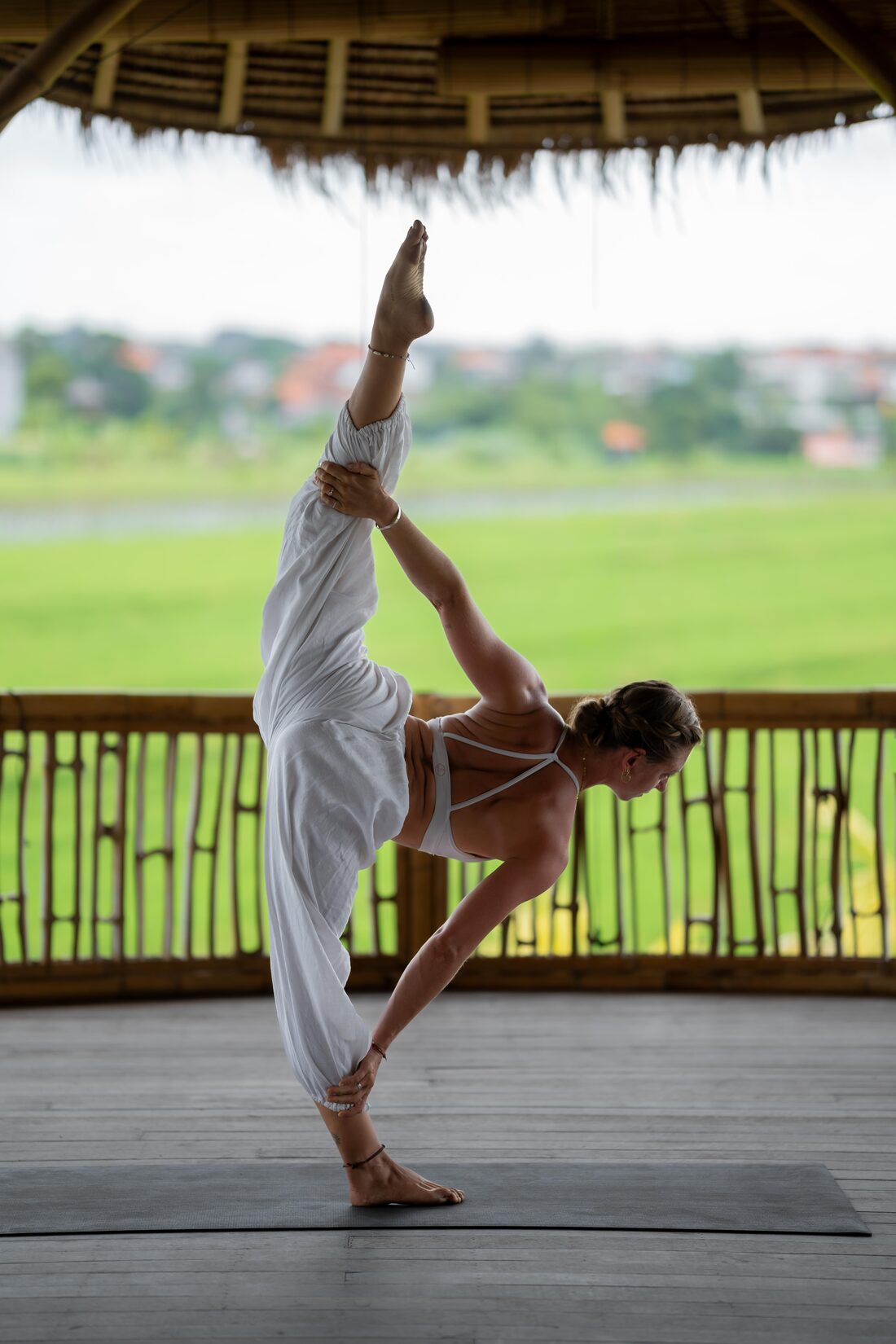 Michelle in a standing split, holding her extended leg toward the sky