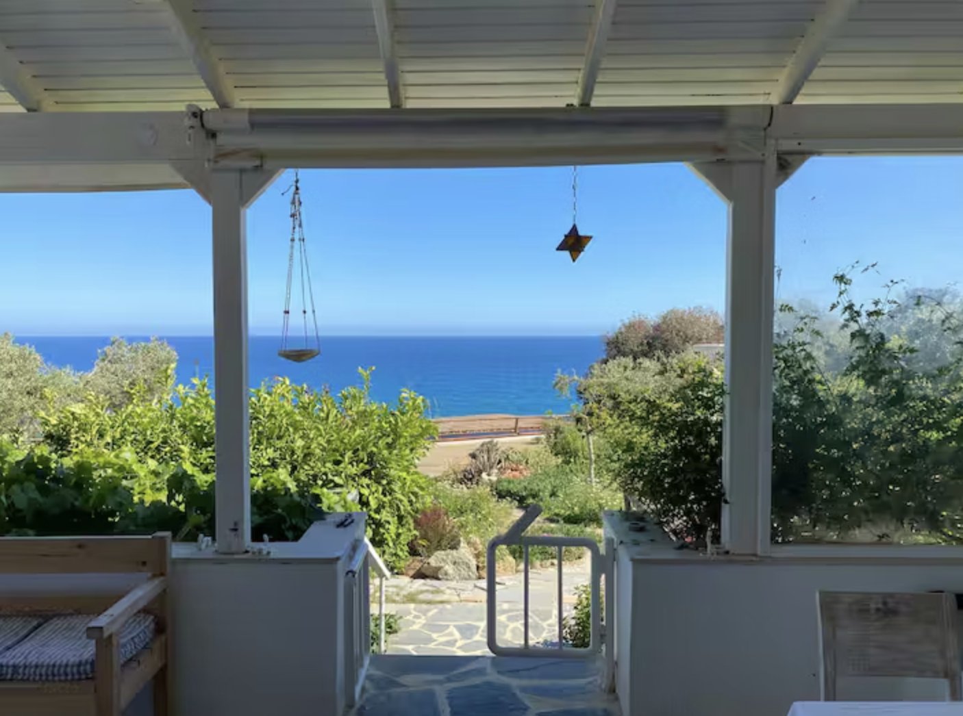 View out to the sea through the shaded pergola of the retreat house in Ferma, Crete